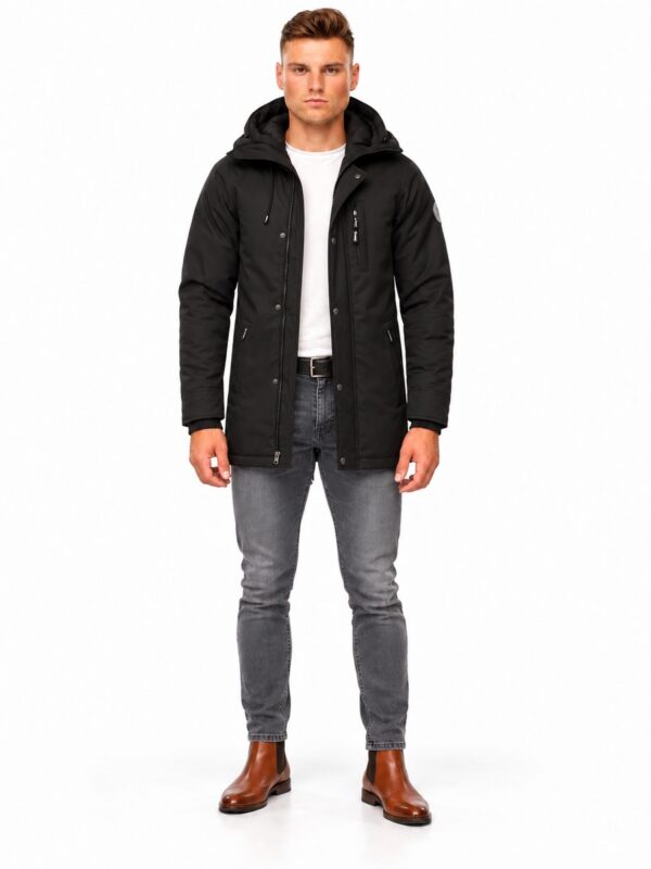 Thomas N zwart van Versano, open op model met wit shirt, grijze slim-fit jeans en cognac schoenen